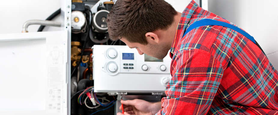Heizungsinstallateur schraubt an Heizungsanlage - Heizungs-Notdienst